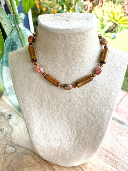 Collar corto artesanal de piedras semipreciosas coral, bambú y jade en exhibidor blanco Natural Coral Jewelry.