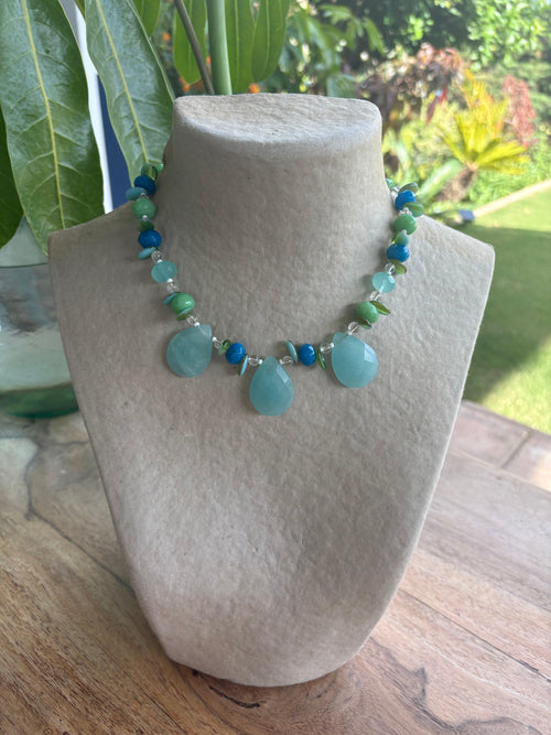 Collar corto artesanal de piedras semipreciosas en tonos azules y verdes mostrado en exhibidor de joyería de Tienda Lutecia.