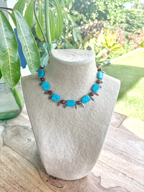 Collar corto artesanal de piedras semipreciosas turquesas y marrones en exhibidor de Joyería Piedras Semipreciosas Luz de Sol.