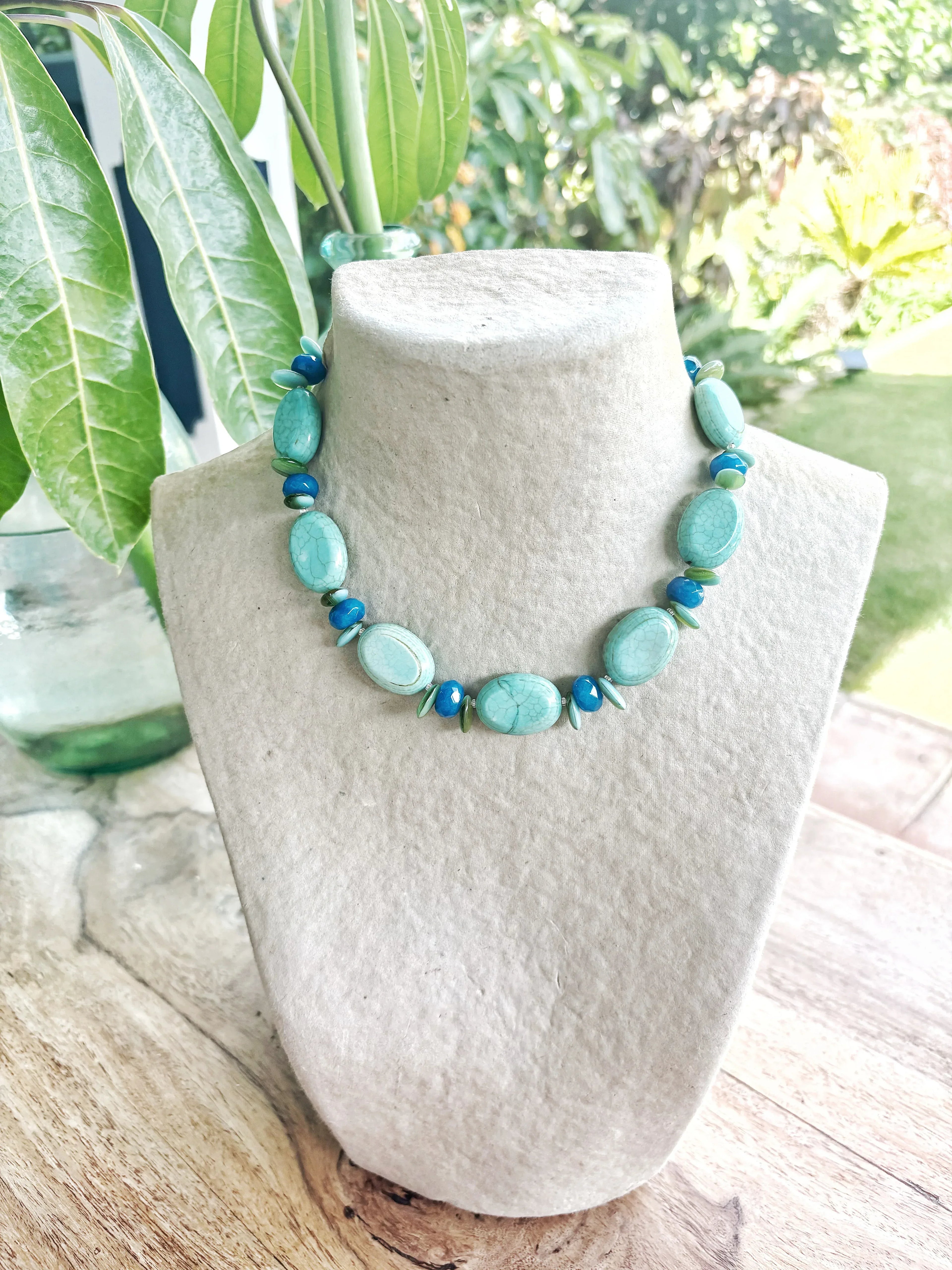 Collar corto artesanal de piedras semipreciosas turquesas y verdes en vitrina blanca, joyería piedras semipreciosas de La.